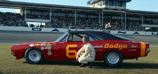 Charlie glotzbach kneels next to his #6 Cotton Owens Dodge for photos in February 1969, prior to the 1969 Daytona 500.